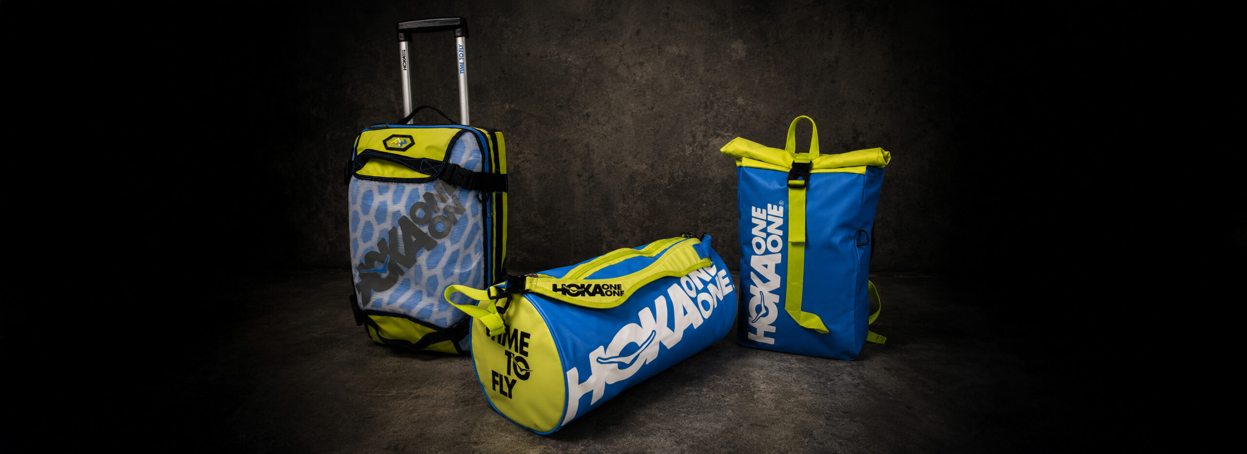 HOKA ONE ONE technical bags collection featuring trolley, duffle bag and roll-top backpack